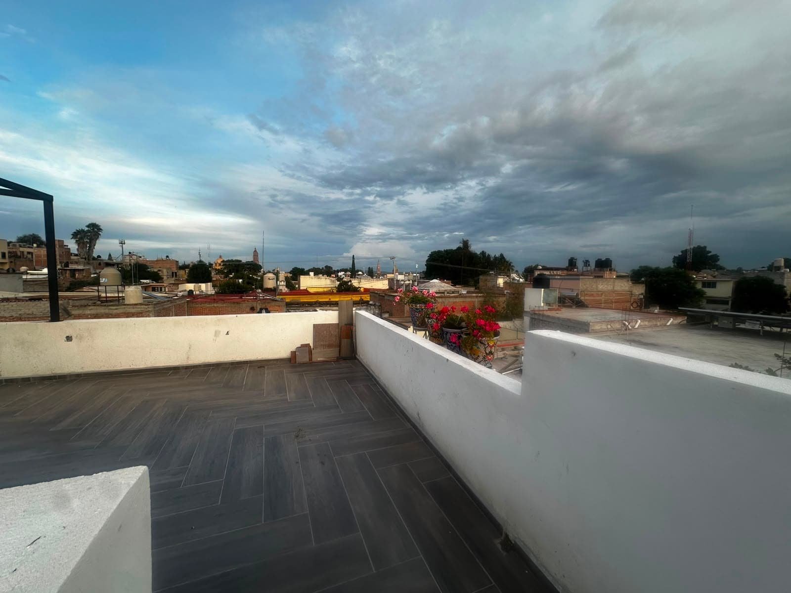 Macetas de talavera y buganvilia sobre el pretil de la terraza, a última hora de la tarde